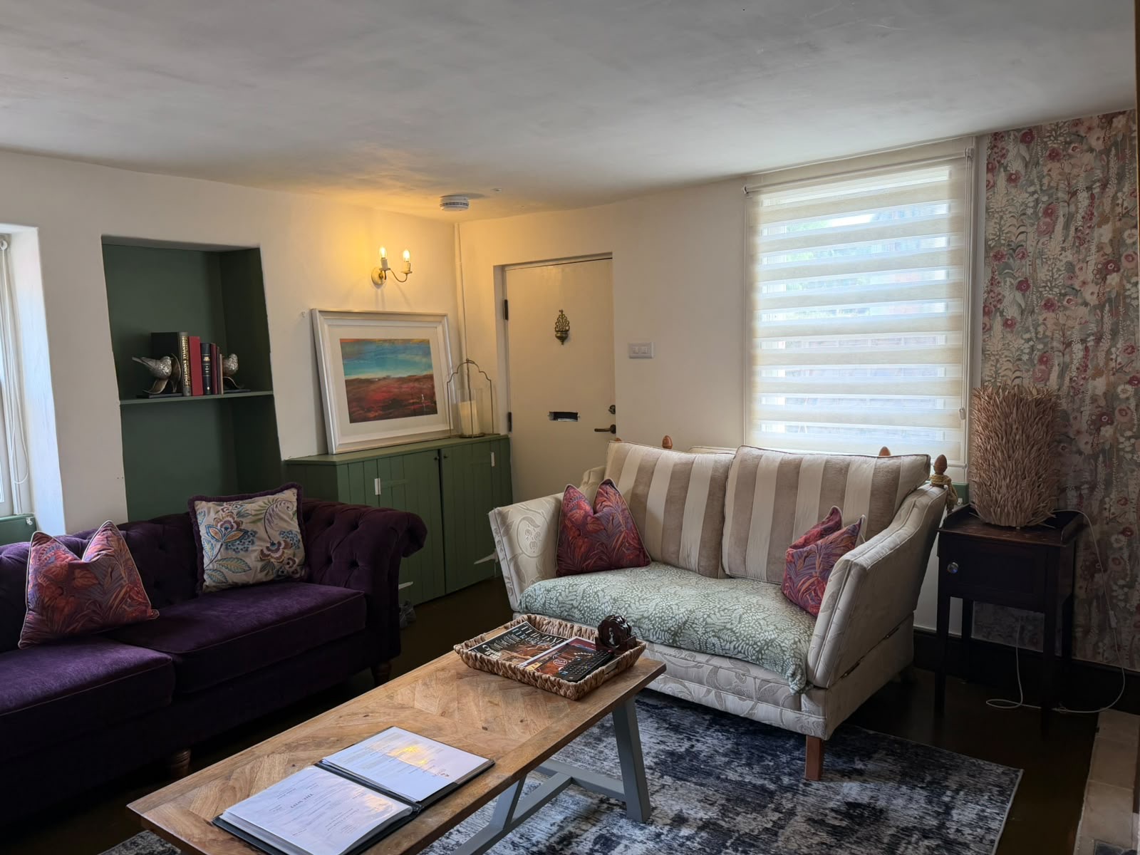Cottage lounge with velvet sofas and floral cushions