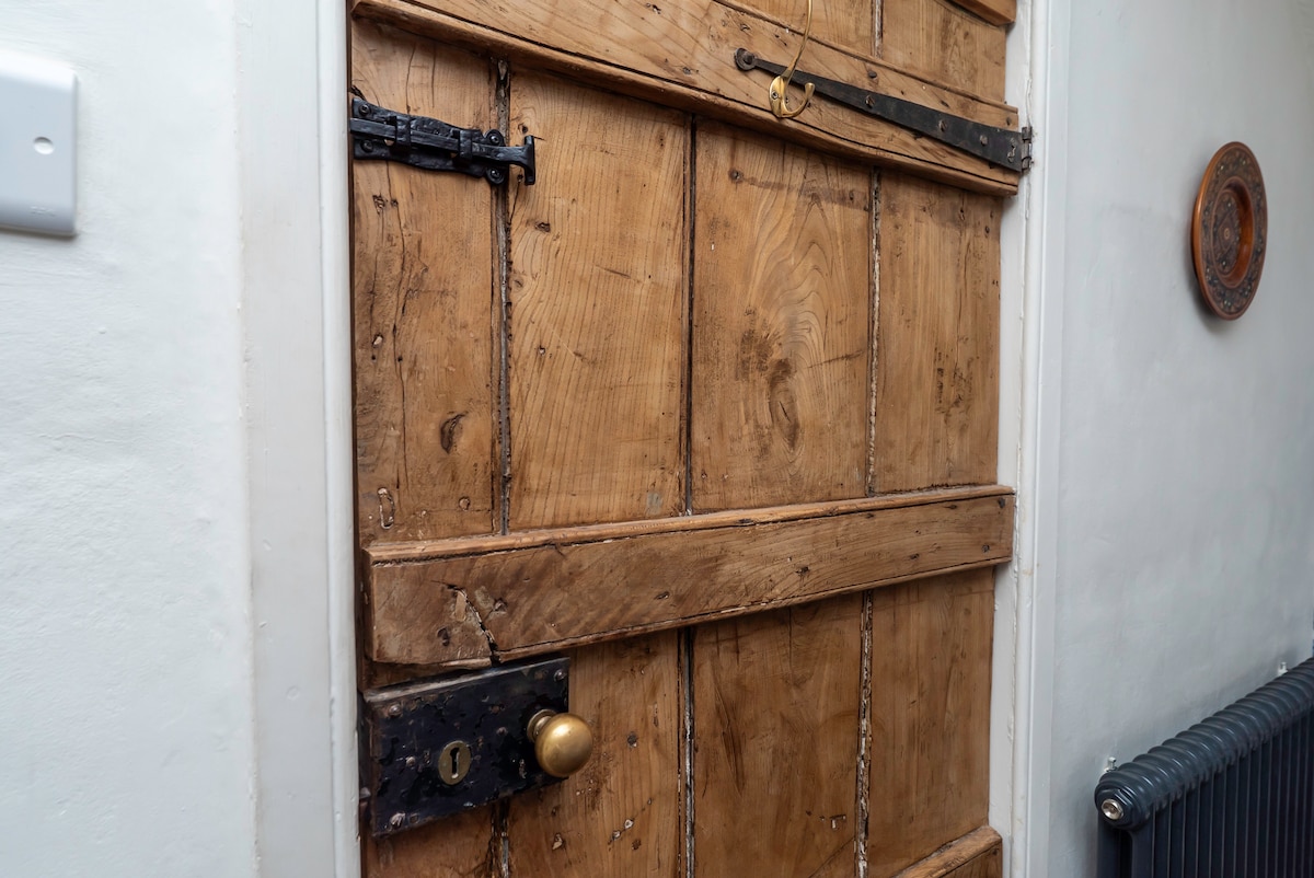 Close-up of a 16th-century plank door with iron hinges and brass knob