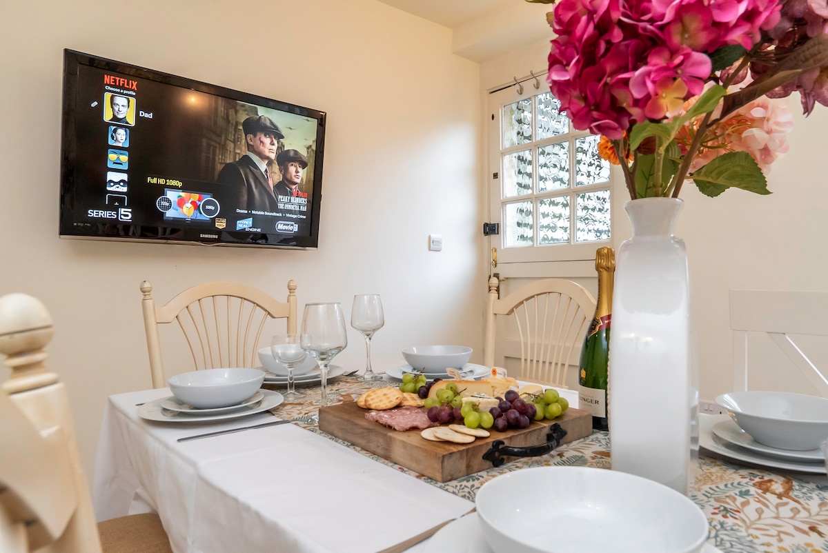 Cottage dining table laid with a sharing board and sparkling wine