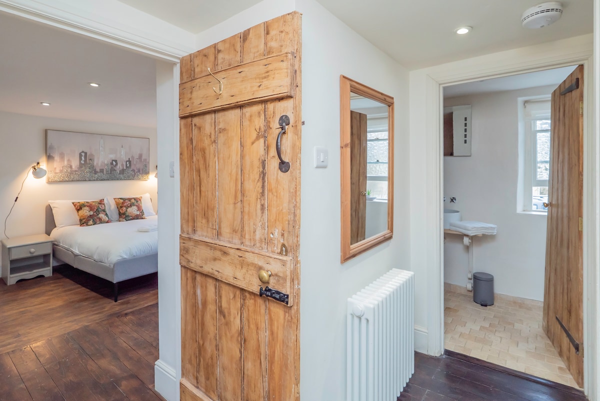 Landing with an original plank door looking through to a bedroom and wet room